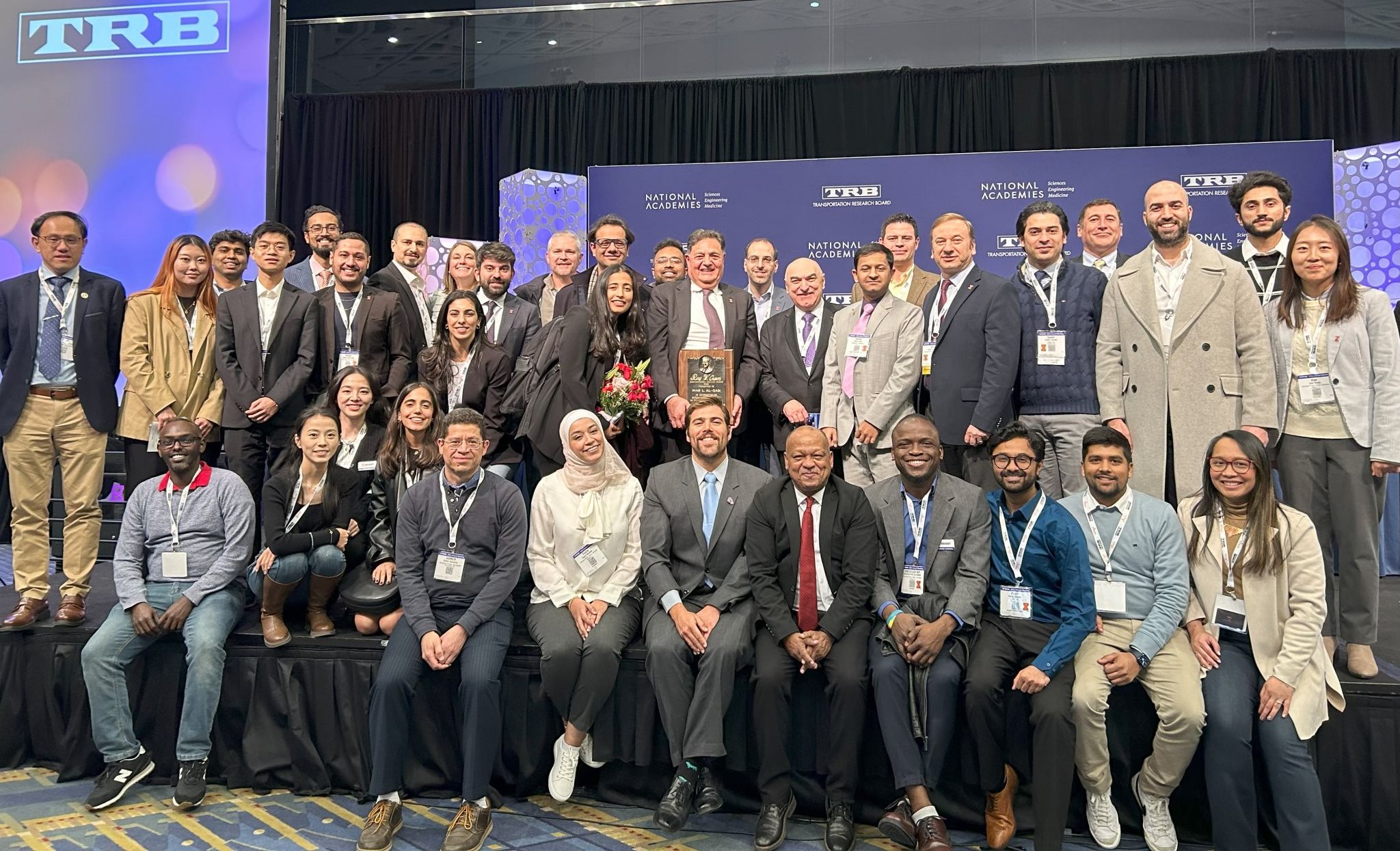 Osman, bottom row fifth from the right, smiles at an award ceremony for&nbsp;Al-Qadi, who received the Roy W. Crum Distinguished Service Award at the Transportation Research Board on January 10, 2024.