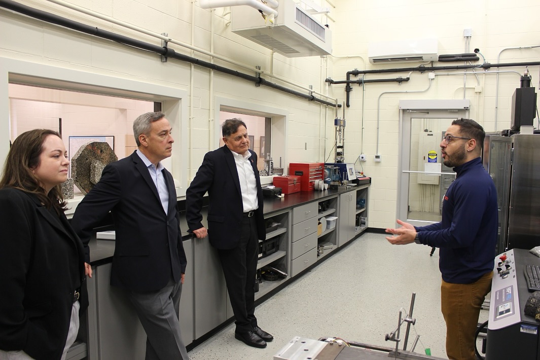 Mandy Drendel of Cornerstone Government Affairs (far left), Michael Sturino of the Illinois Road and Transportation Builders Association (second from left) and Imad Al-Qadi, ICT director, listen as Renan Maia, ICT doctoral student, explains research in the ICT lab on April 11.