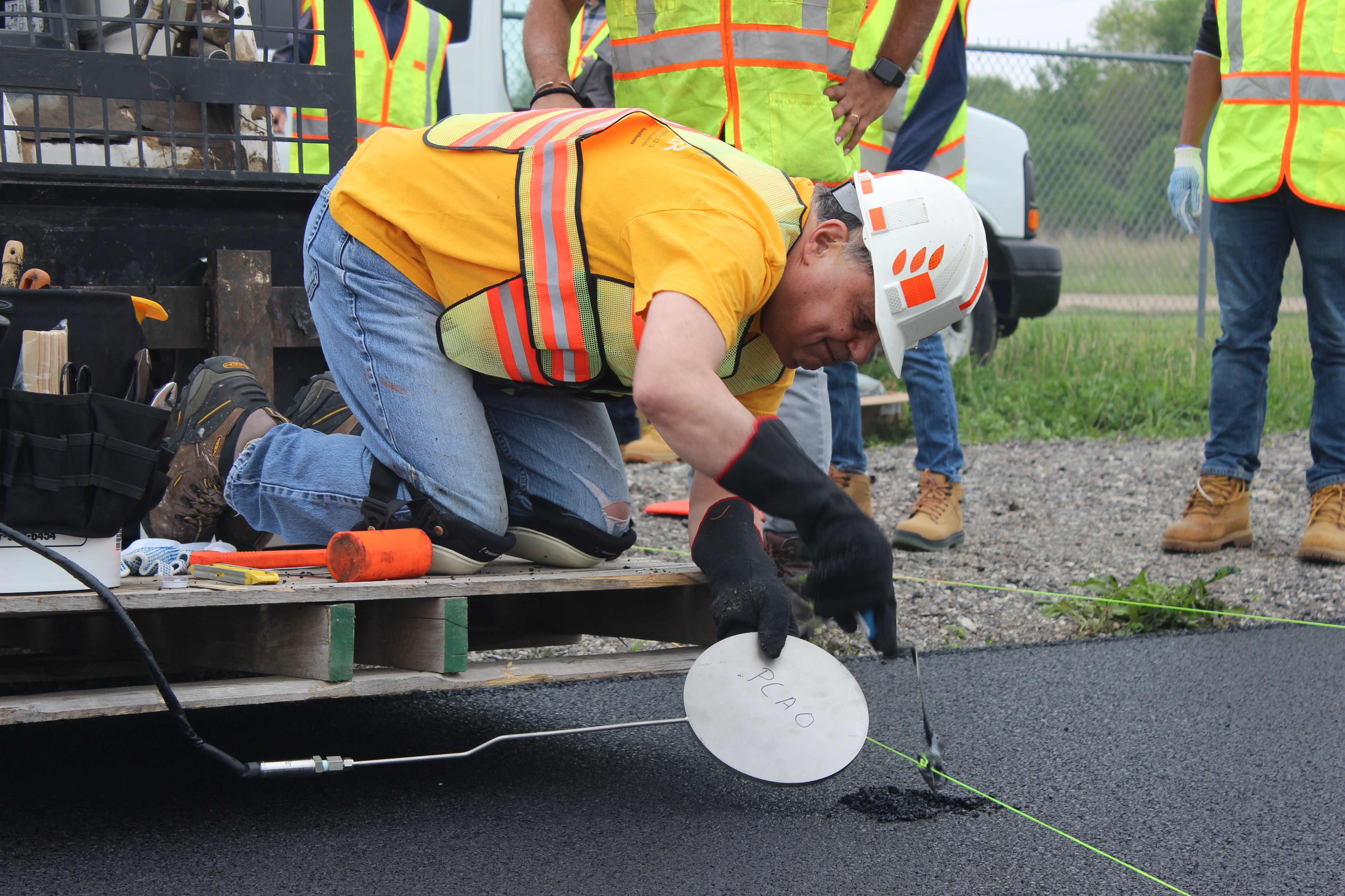 Al-Qadi placing instrumentation on an asphalt pavement.