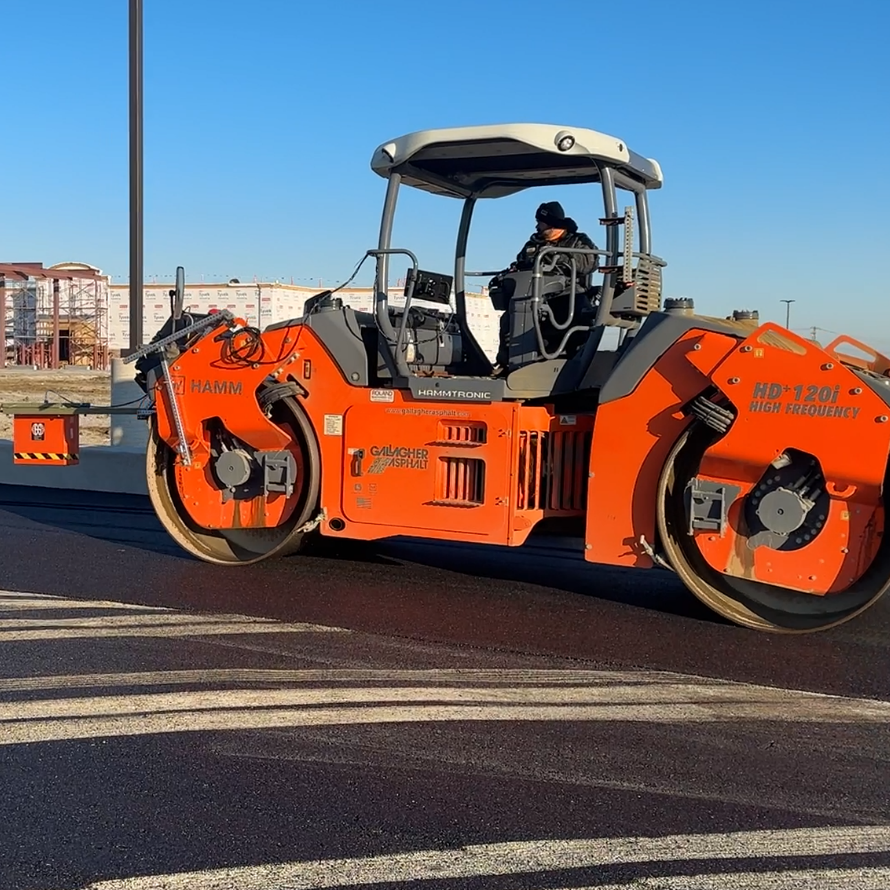 A roller compactor with a ground-penetrating radar attached to the front.