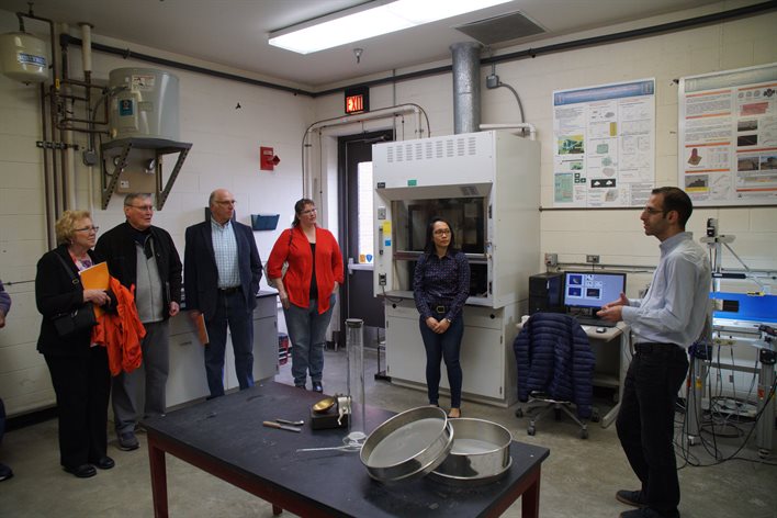 Isaam Qamhia, right, UIUC Department of Civil and Environmental Engineering doctoral candidate, gives a tour of the Advanced Transportation Research Laboratory to local leaders following the Village of Rantoul&rsquo;s special board meeting at ICT.