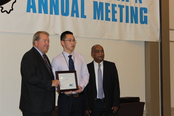 UIUC doctoral student Zehui Zhu, center, proudly displays his award posing with Sen. Donald DeWitte (R-St. Charles), left, and Illinois Department of Transportation Secretary Omer Osman during the 82nd annual IAPA Meeting.