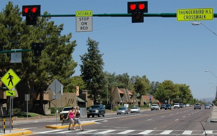 Mike Cynecki/<a href="http://www.pedbikeimages.org/">Ped Bike Images</a><br />Pedestrians in Phoenix, Ariz., use a pedestrian hybrid beacon to cross the street.