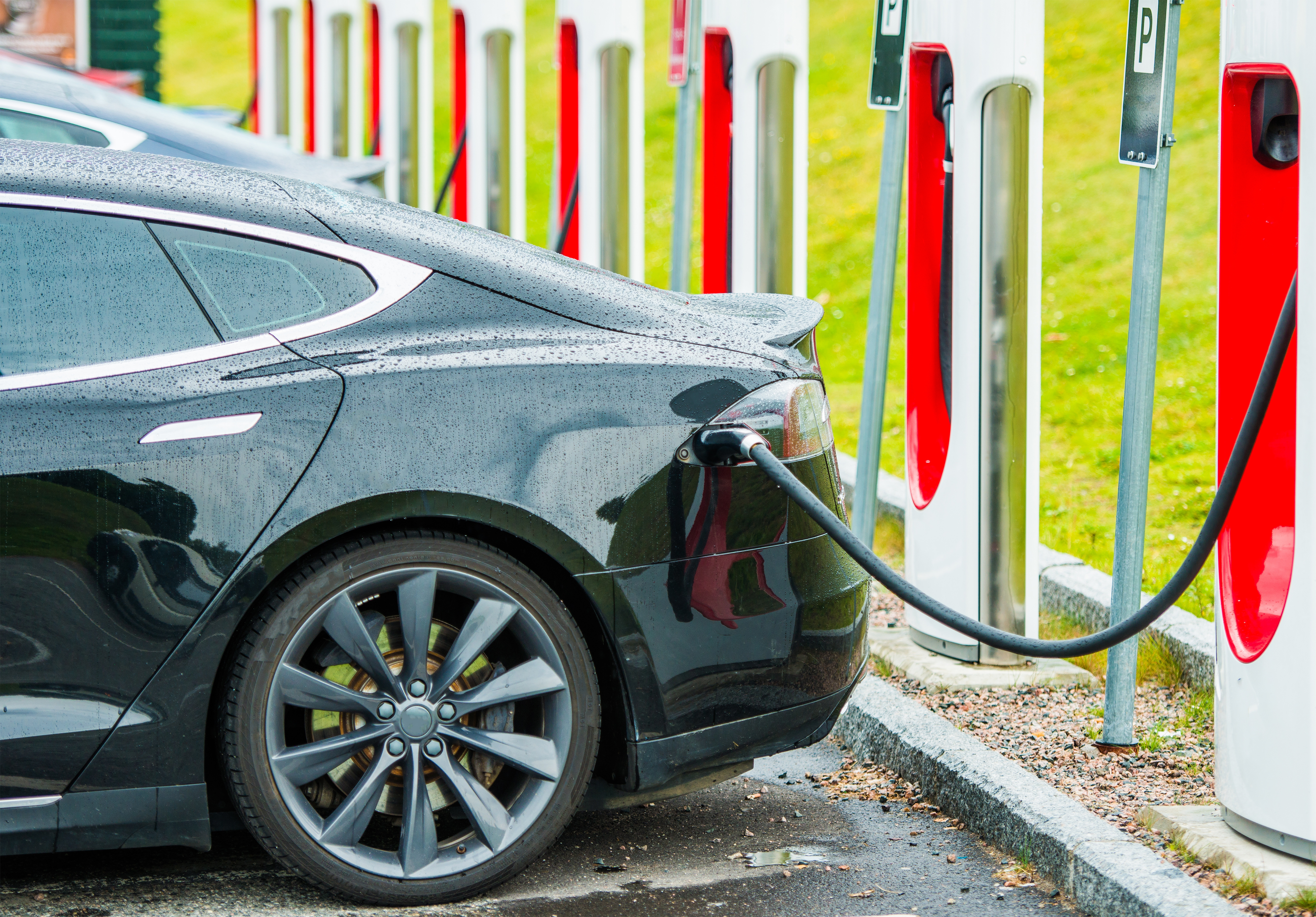 An electric vehicle charges at a local charging hub.