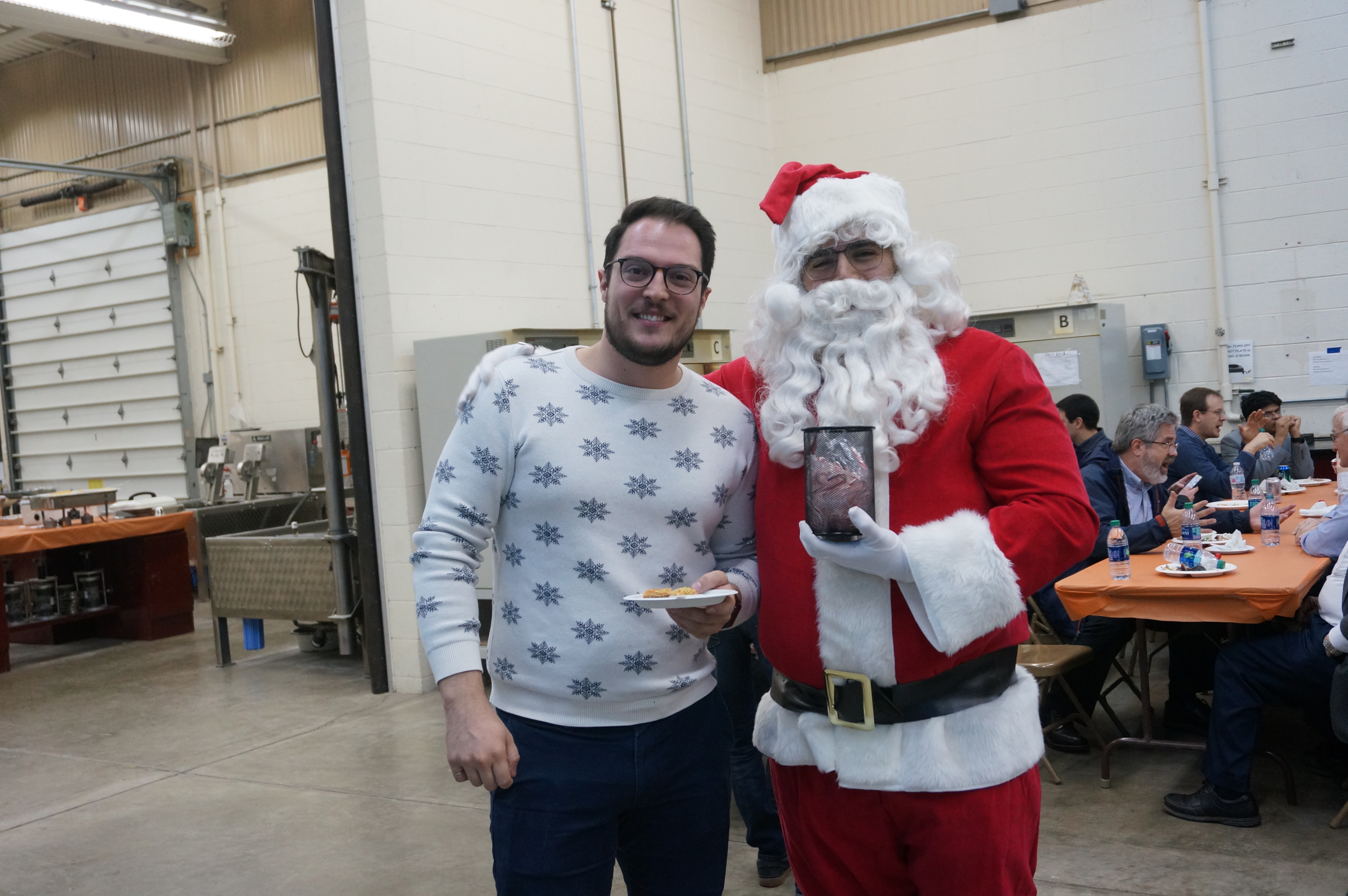 UIUC master&rsquo;s grad Javier Garc&iacute;a Mainieri, right, is all smiles while donning a Santa Claus costume and posing with classmate Jordan Ouellet, a UIUC doctoral student, during an annual Winter Open House at Illinois Center for Transportation in Rantoul, Illinois.
