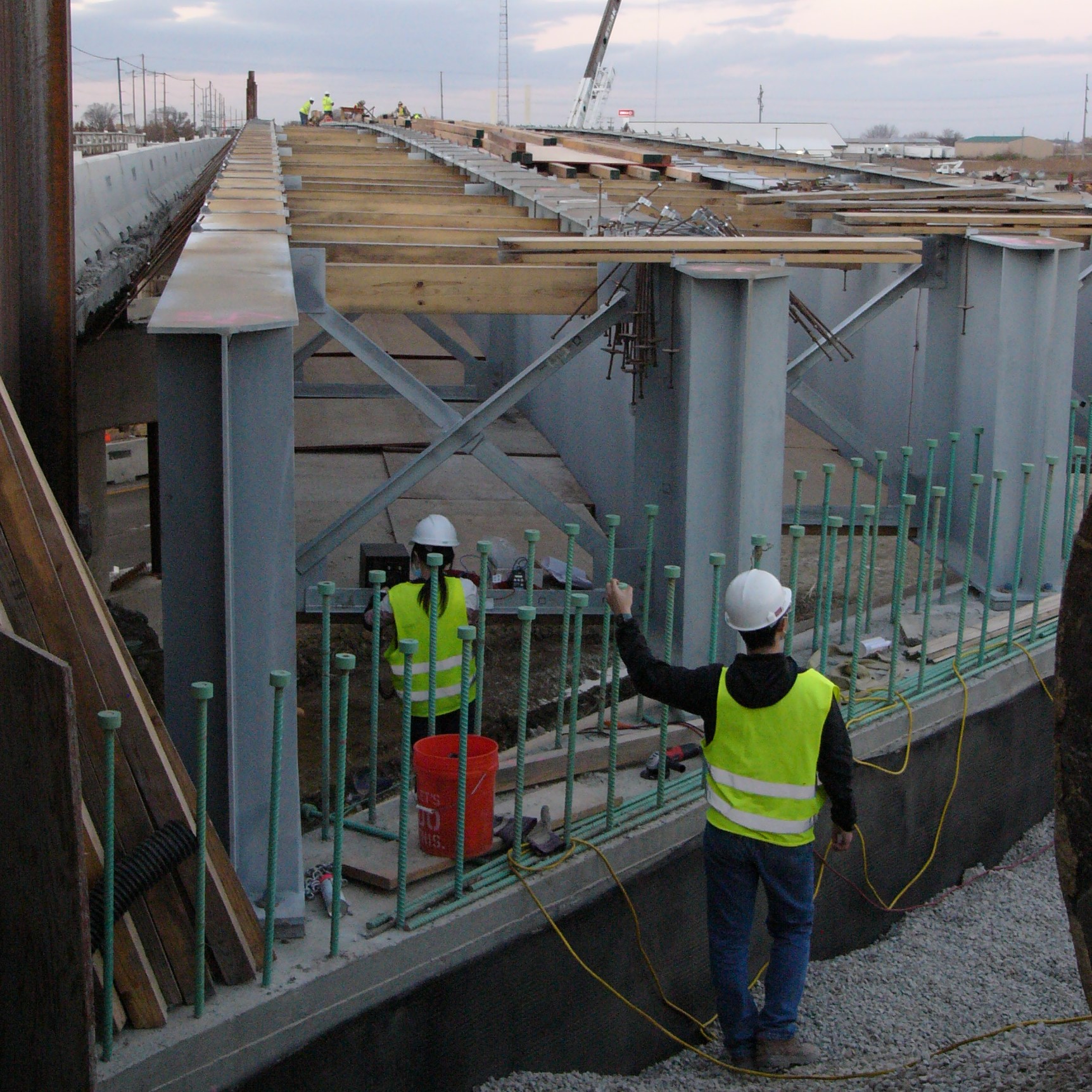 Provided by Larry Fahnestock. University of Illinois at Urbana-Champaign graduate students Sunny Zhou and Gaoyu Liu install strain gauges on X-shaped cross frames at Mattis Avenue Bridge over I-57 in Champaign, Illinois, on Nov. 9, 2020. The bridge over I-57 has integral abutments &mdash; where the girders are encased in concrete at the ends &mdash; whereas the bridge over I-74 has expansion bearings at the ends that allow movement.