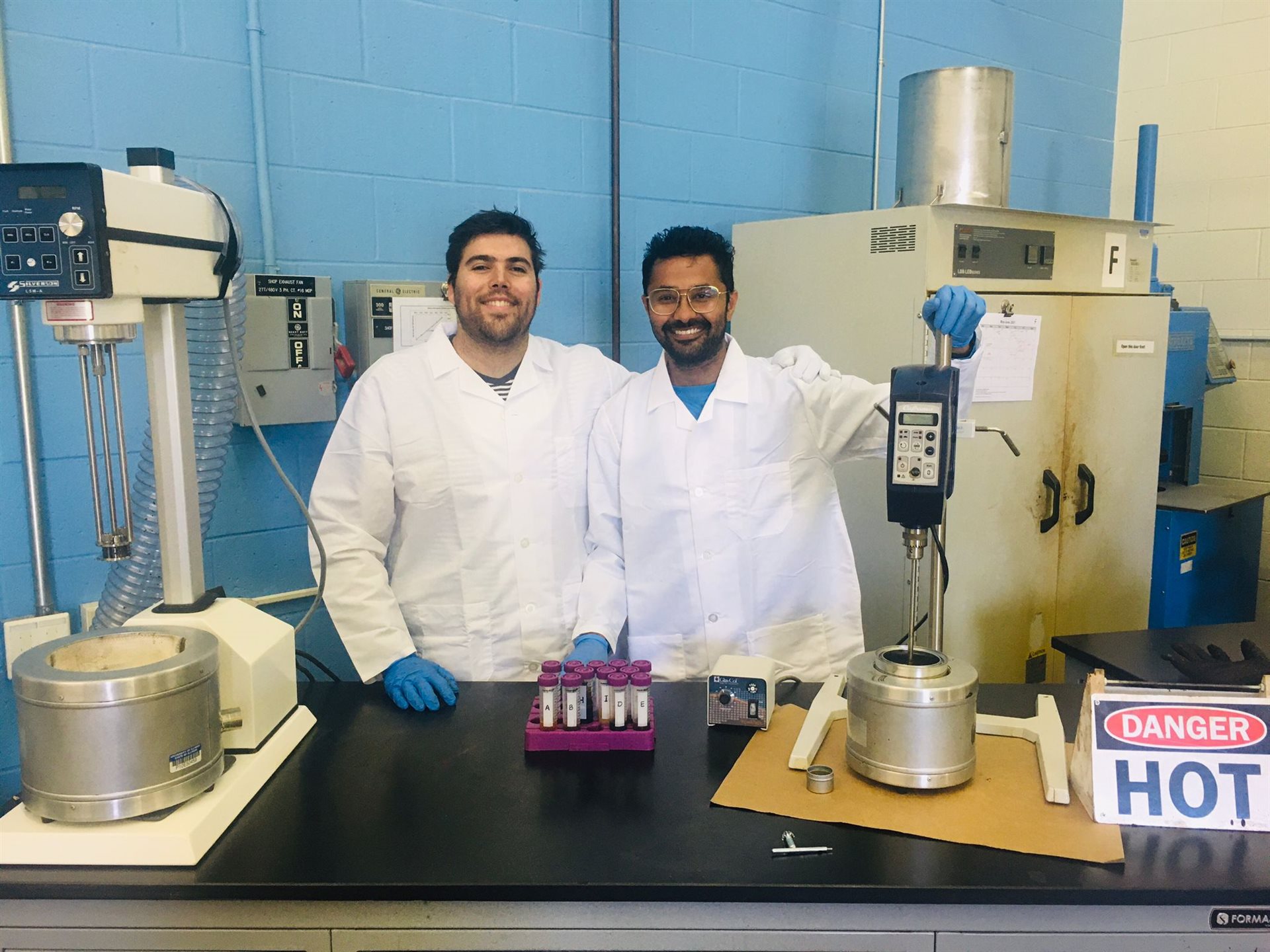 University of Illinois Urbana-Champaign graduate students, from left, Javier Garc&iacute;a Mainieri and Punit Singhvi pose with the asphalt binder modifiers and equipment used for the project at the Advanced Transportation Research and Engineering Laboratory in Rantoul, Ill.