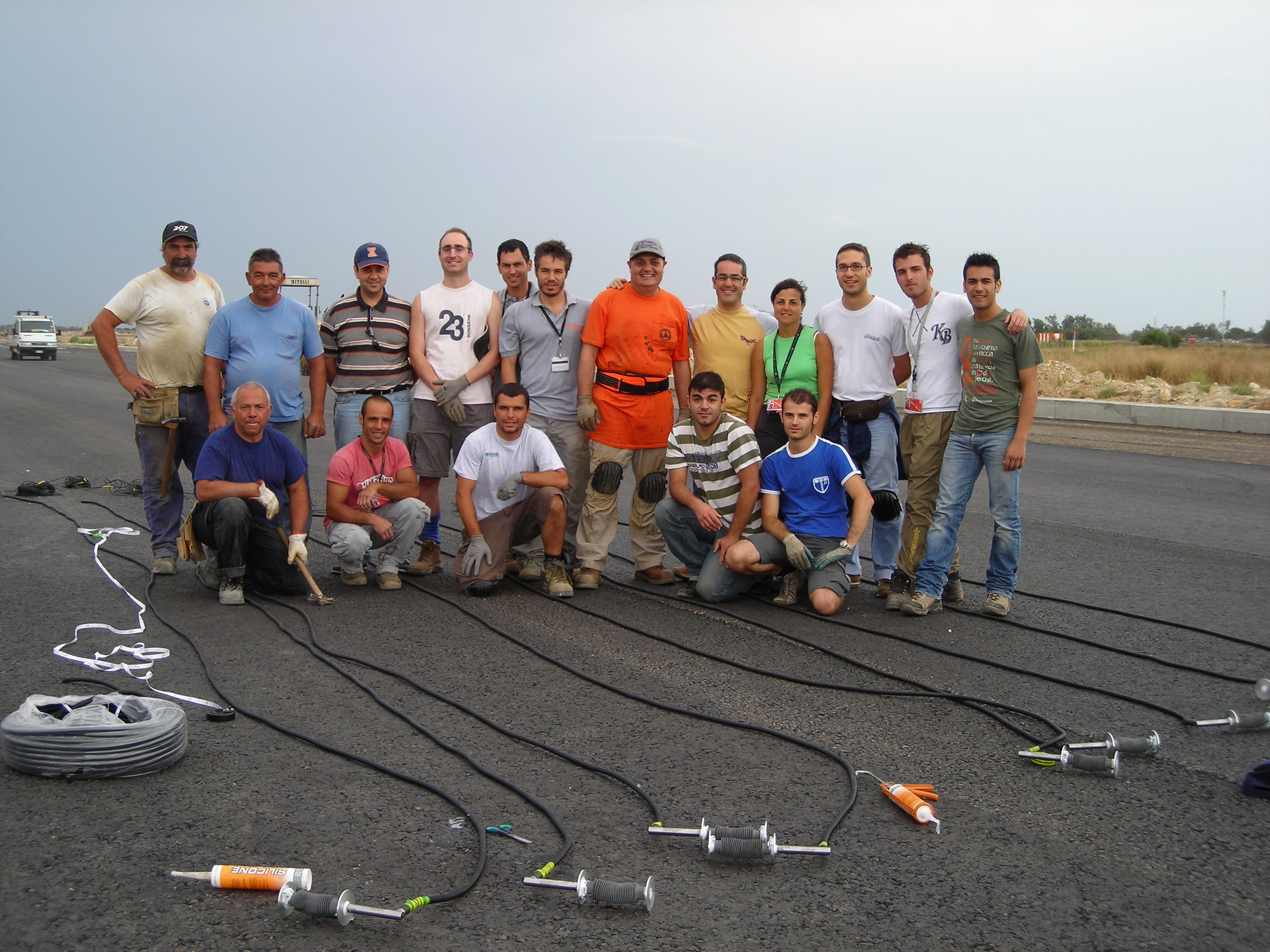 Imad Al-Qadi with University of Cagliari students and researchers at an airport in Italy. They are installing the first instrumentation &mdash; sensors used to monitor pavement response to moving airplanes and environment &mdash; at a European airport. The shown deflection system was designed by Al-Qadi.