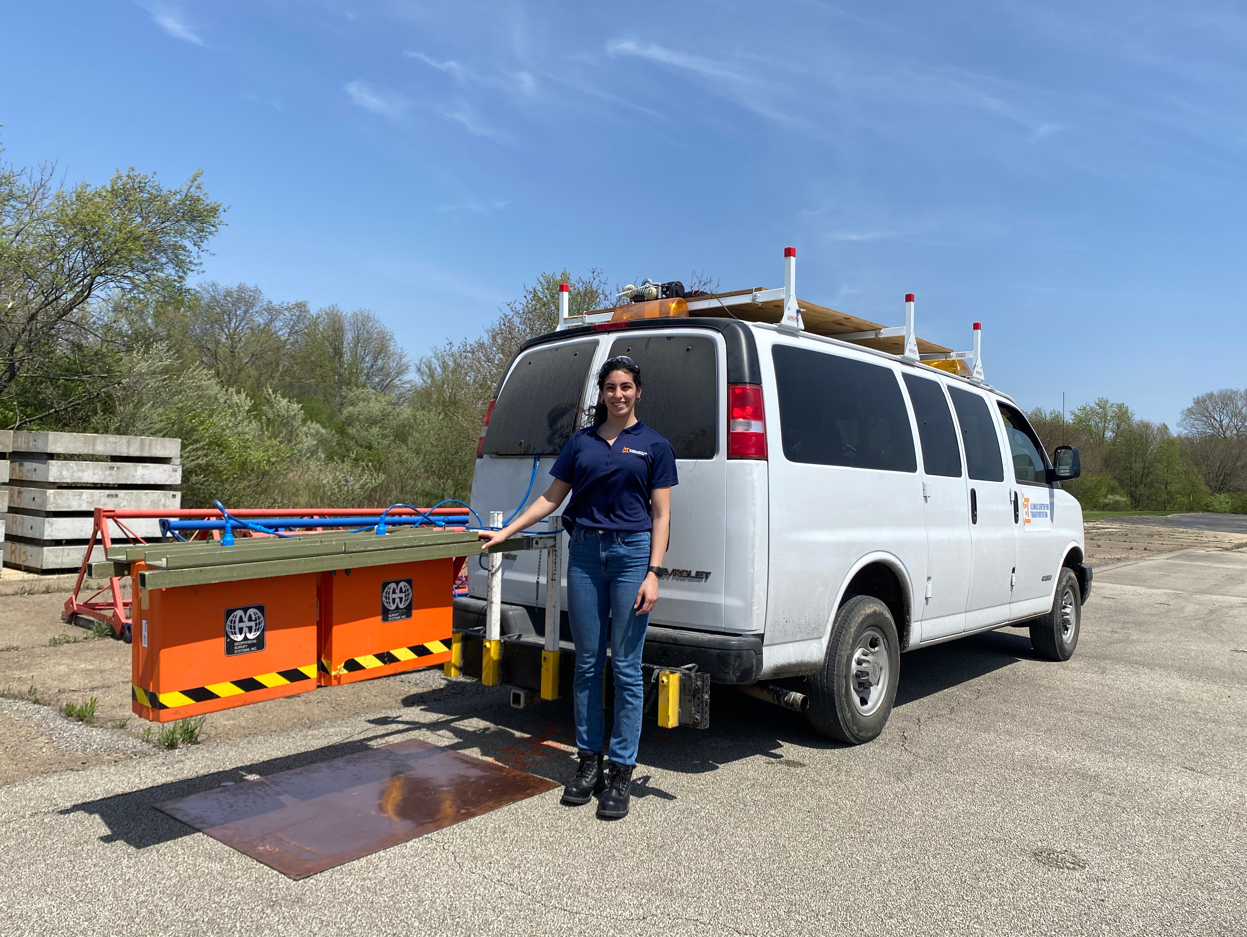 Lama Abufares, a Department of Civil and Environmental Engineering doctoral student, poses with the ground-penetrating radar device behind the Illinois Center for Transportation in Rantoul, Ill. Qingqing Cao and Siqi Wang, recent CEE doctoral graduates, also contributed to the project. GPR detects the dielectric properties of target materials. Water has a very high dialectic constant (close to 81) compared to pavement materials such as asphalt binder (3), aggregate (between 3 to 10), and air voids (1).