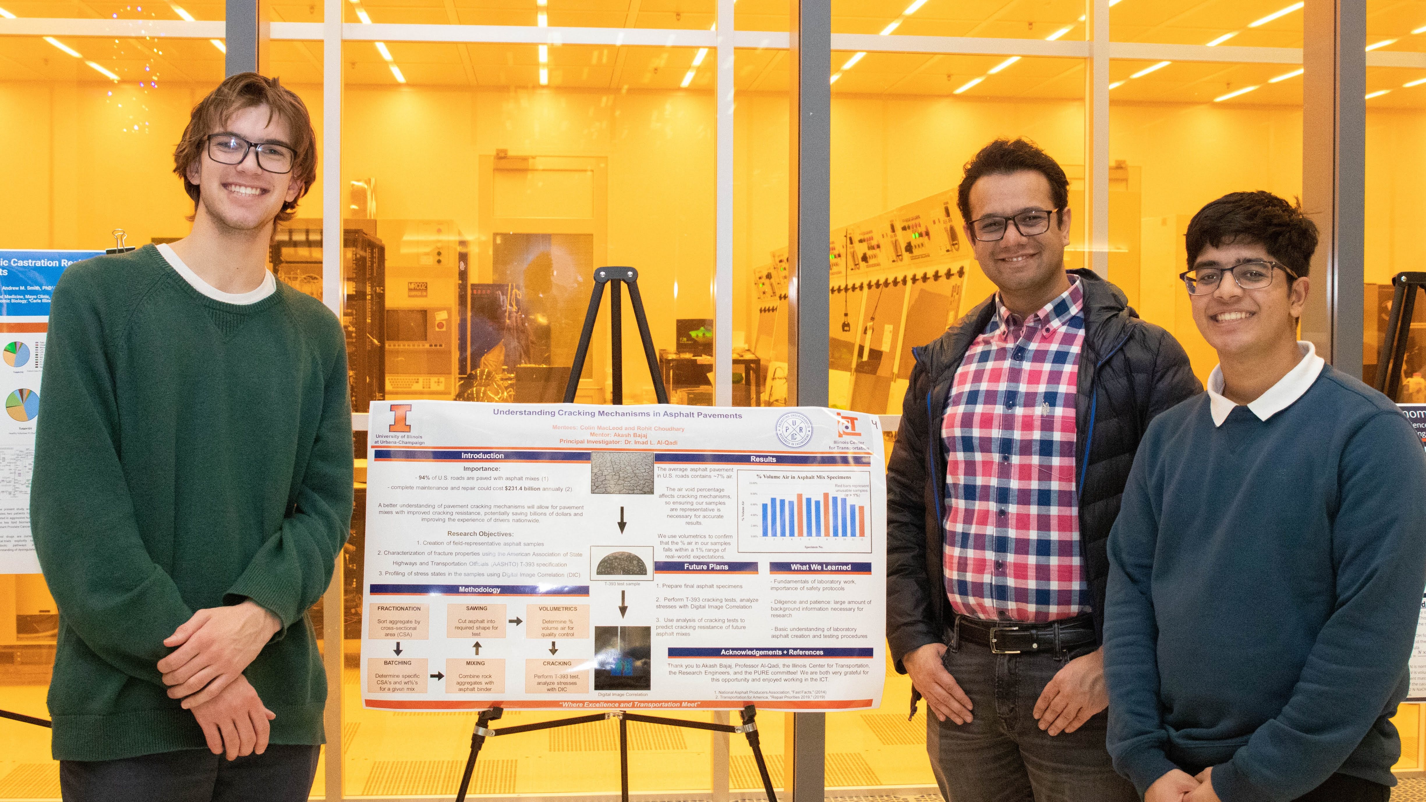 UIUC students Colin Macleod (left) and Rohit Choudhary (right) smile in front of their research poster with mentor Akash Bajaj, a Department of Civil and Environmental Engineering doctoral candidate.