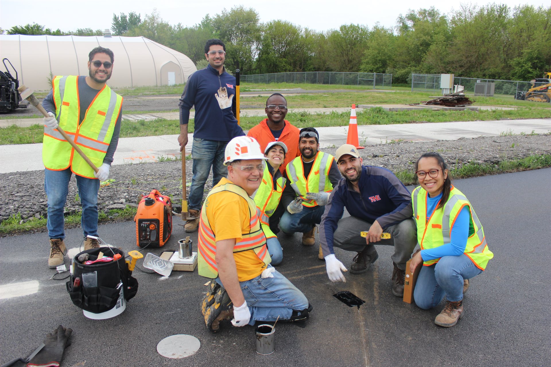 Illinois Center for Transportation staff and student smile with Imad Al-Qadi, ICT director and CEE Grainger Distinguished Chair in Engineering, while constructing the test site in Rantoul, Illinois.